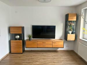 a living room with a flat screen tv on a entertainment center at Modernes Reihenhaus mit Terrasse drei Schlafzimmer fuer sechs Personen in Kempten