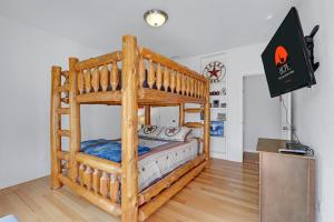 a wooden bunk bed in a room with a tv at Rio Cantando in Wimberley