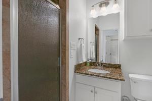 a bathroom with a sink and a toilet and a mirror at Rio Cantando in Wimberley