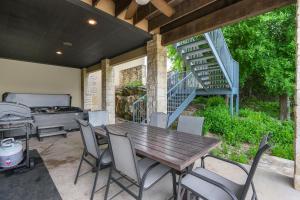 a patio with a table and chairs and a staircase at Rio Cantando in Wimberley