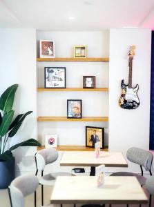 a room with tables and a guitar on the wall at Montrose at Beverly Hills in Los Angeles