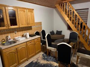 a kitchen with a sink and chairs and a staircase at Apart Cobras Jajce in Jajce +55 photos