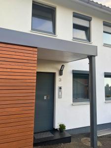 a house with a garage with a green door at Modernes Reihenhaus mit Terrasse drei Schlafzimmer fuer sechs Personen in Kempten