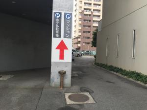 a pole with a sign on it next to a parking garage at Hotel Crown Hills Kofu in Kofu
