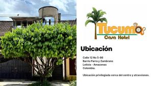 a tree in front of a building with an advertisement for a car house at Tucuma Casa Hotel in Leticia