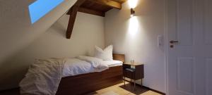 a small bedroom with a bed and a window at Woodlight Loft - Sauna & Nature Escape near Rothenburg ob der Tauber - Self Check-in in Diebach