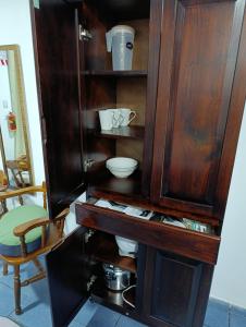 a wooden cabinet with bowls and dishes in it at Apartamentos Novoa in San José +40 photos