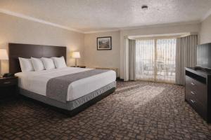 a hotel room with a bed and a television at Discovery Inn in Midvale