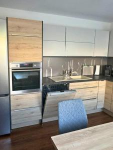 a kitchen with stainless steel appliances and a blue chair at Modernes Reihenhaus mit Terrasse drei Schlafzimmer fuer sechs Personen in Kempten