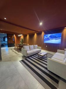 a living room with couches and a large screen at Casa mansa hostel in Maldonado
