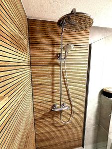 a shower in a bathroom with a wooden wall at Familienfreundliche Ferienwohnung mit Garten & Spielplatz nahe Nürnberg Playmobil FunPark in Veitsbronn +22 photos
