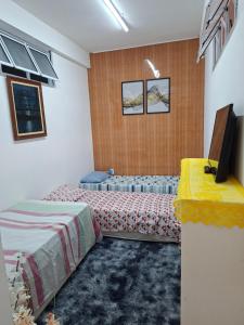 a bedroom with two beds and a television in it at Interlagos Family House in São Paulo +15 photos