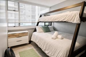 a bedroom with two bunk beds and a window at Torre Ambar Executive Residences in San José +40 photos