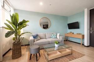a living room with a couch and a mirror at Torre Ambar Executive Residences in San José