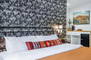 a bedroom with a bed with a black and white wallpaper at Cowboy Casita in Wimberley