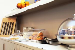 a shelf with a bowl of bread and fruit on it at Residenza del Centro in Fabriano