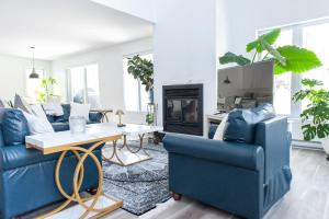 a living room with blue couches and a fireplace at Cozy Cottage, The Getaway in Quebec in Brownsburg