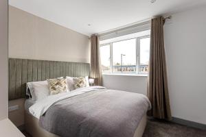 a bedroom with a bed and a large window at Regent Apartments, York in York