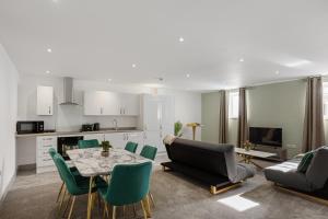 a kitchen and a living room with a table and chairs at Regent Apartments, York in York