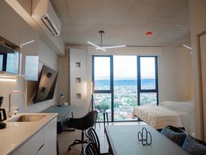 a room with a bed and a kitchen with a sink at Secrt Escalante Premium Studio AC in San Pedro
