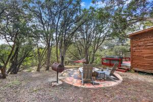 a patio with a barbecue and chairs and a grill at Cozy Cabin in Wimberley