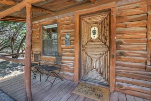 a cabin with a wooden door and a chair on a porch at Cozy Cabin in Wimberley