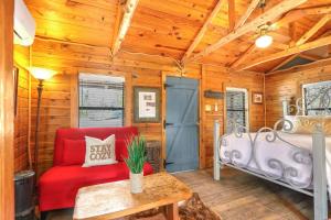 a room with a red couch and a bed in a cabin at Cozy Cabin in Wimberley +15 photos