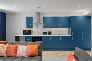 a living room with blue cabinets and a couch at Regent Apartments, York in York +43 photos