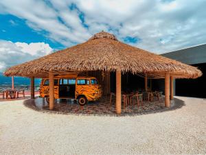 a van parked under a straw umbrella on the beach at Secrt Escalante Premium Studio AC in San Pedro
