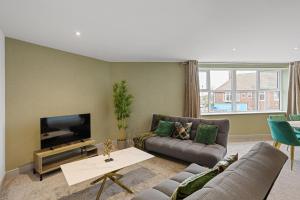 a living room with a couch and a flat screen tv at Regent Apartments, York in York