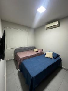 a room with two beds and a tv in it at Casa Condeixa in Cabo Frio +13 photos