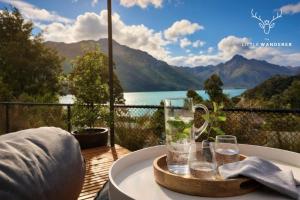 a tray of glasses on a table with a view of a lake at The Little Wanderer in Queenstown