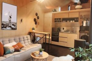 a living room with a couch and a kitchen at The Little Wanderer in Queenstown +13 photos