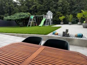 a table with chairs and a playground in a backyard at Familienfreundliche Ferienwohnung mit Garten & Spielplatz nahe Nürnberg Playmobil FunPark in Veitsbronn