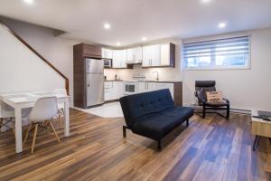 a living room with a blue couch and a kitchen at Appartement 2 chambres, centre ville, séjour longue durée in Quebec City