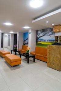 a waiting room with orange furniture in a hospital at Hotel Plaza Muisca in Tunja +40 photos