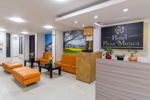 a lobby of a hotel with chairs and a sign at Hotel Plaza Muisca in Tunja