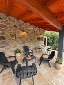 a patio with chairs and a table and a stone wall at Cabaña julian in Villa Berna