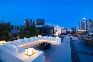 a rooftop patio with white furniture and a city skyline at Chengdu Yunduo 云朵Hotel in Chengdu