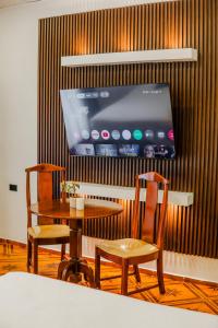 a room with a table and two chairs and a tv at Hotel Antigua Comayagua in Comayagua