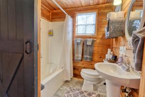 a bathroom with a toilet and a sink and a tub at Creekside Cabins - The Texan in Wimberley