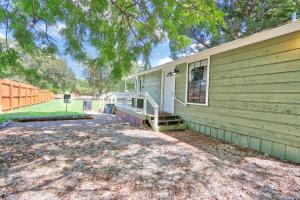 a green house with a porch and stairs to the door at Creekside Cabins - The Texan in Wimberley