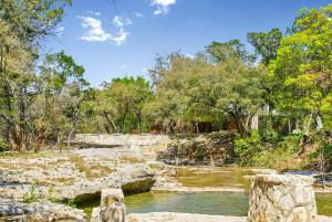 a bridge over a river in a park at Creekside Falls in Wimberley