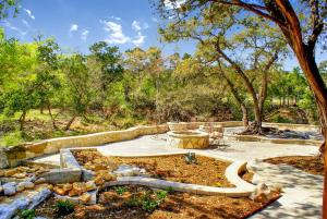 a garden with a fountain in the middle at Creekside Falls in Wimberley