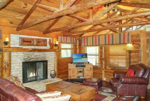 a living room with a fireplace and leather furniture at Creekside Falls in Wimberley