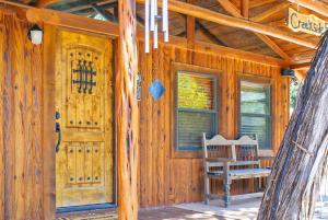 a wooden cabin with a door and a chair on a porch at Creekside Falls in Wimberley