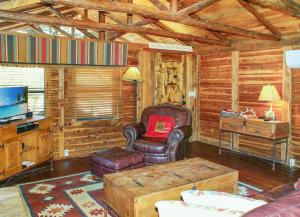 a living room with a chair and a television in a cabin at Creekside Falls in Wimberley +16 photos