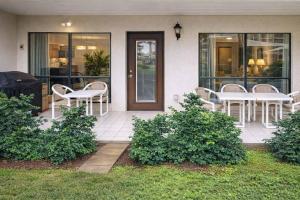 a patio with white tables and chairs on a house at Saida Towers IV #108 condo in South Padre Island