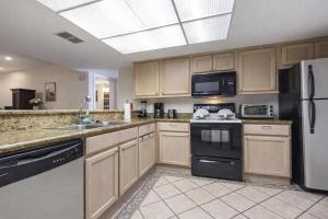 a large kitchen with wooden cabinets and appliances at Saida Towers III- 3101 condo in South Padre Island