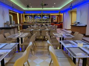 a restaurant with tables and chairs and a bar at Trigo Hotel Kuala Lumpur in Kuala Lumpur